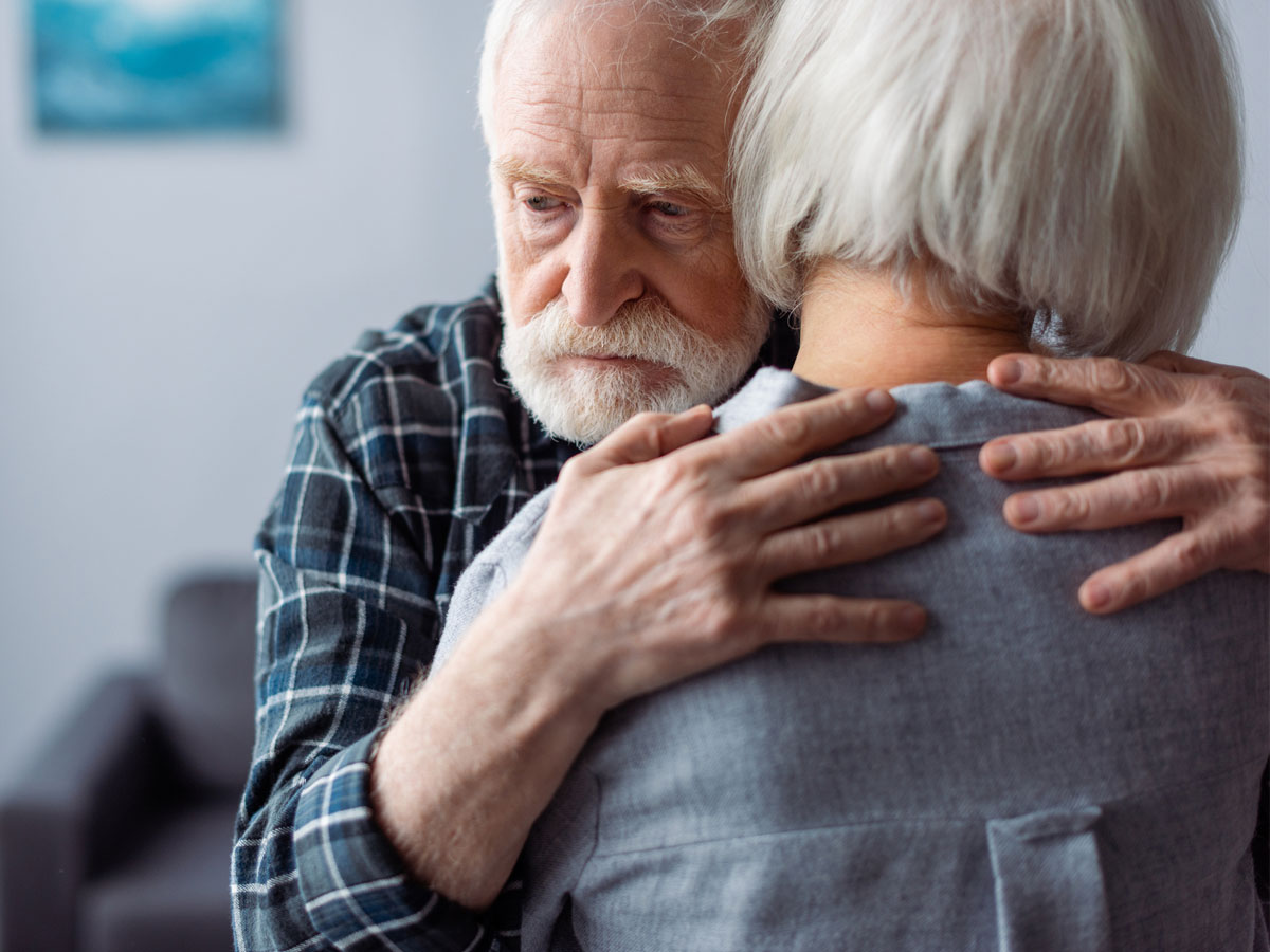 Man and woman sadly holding each other