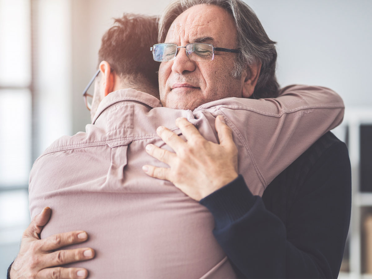 A father and son hugging after the unattended death of a family member in Gulf Breeze, FL